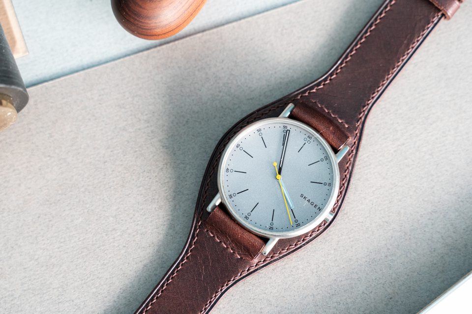 The pale dial framed by dark brown leather and light perimeter stitching.