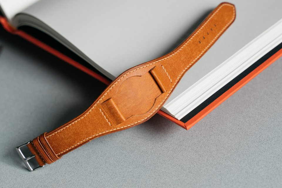 Golden tan Bund strap from its buckle through the shaped centre and taper.