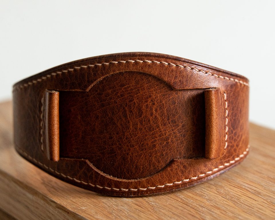 Textured cognac Bund strap curved into a loop with its central pad facing forward.